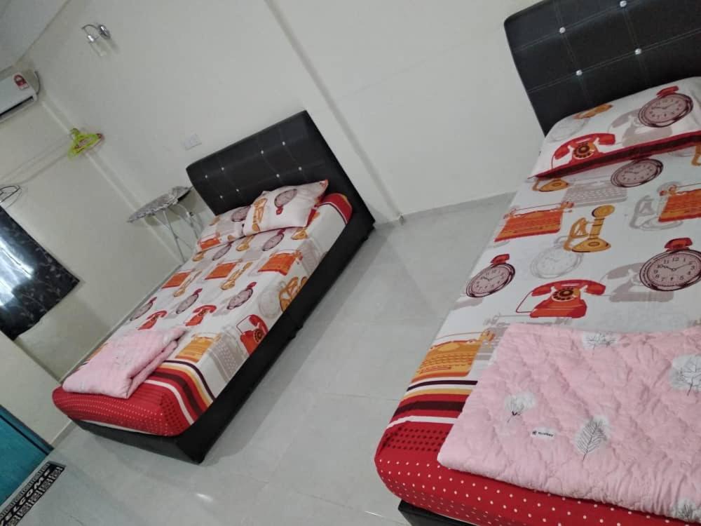 een slaapkamer met 2 bedden en een rode nachtrok bij Niyaz Inn in Pantai Cenang