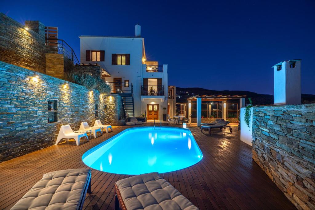 a swimming pool in a villa at night at Belvedere Andros in Batsi