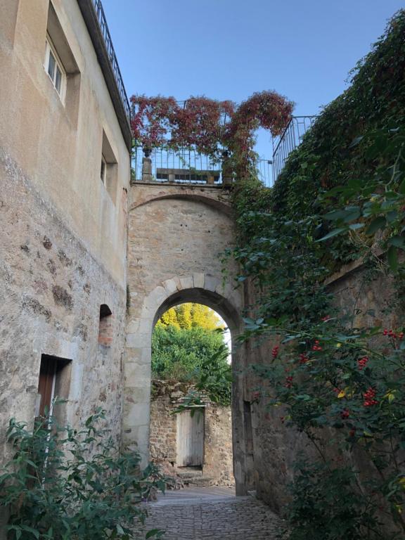 an archway in the side of a stone building at Bâtisse du pont pinard et son granit rose in Semur-en-Auxois