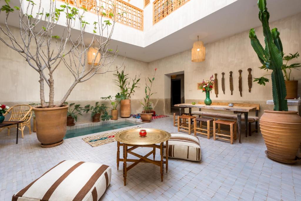 pokój z basenem, stołami i doniczkami w obiekcie Medina Sun w Marakeszu