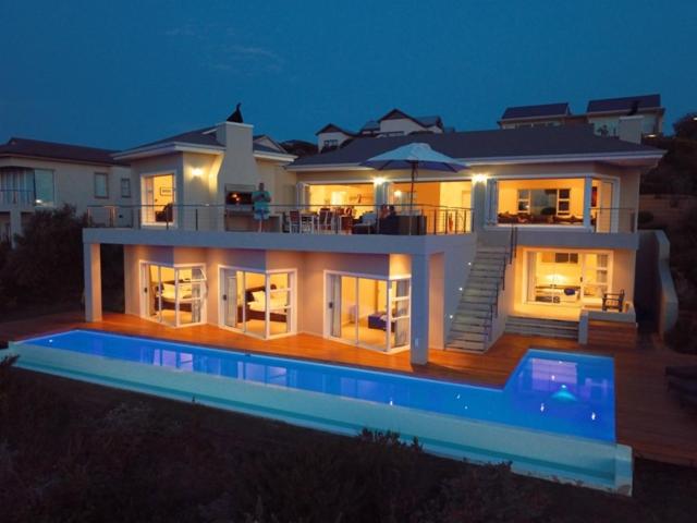 a large house with a swimming pool at night at Brackenridge 11 Protea Dale in Plettenberg Bay