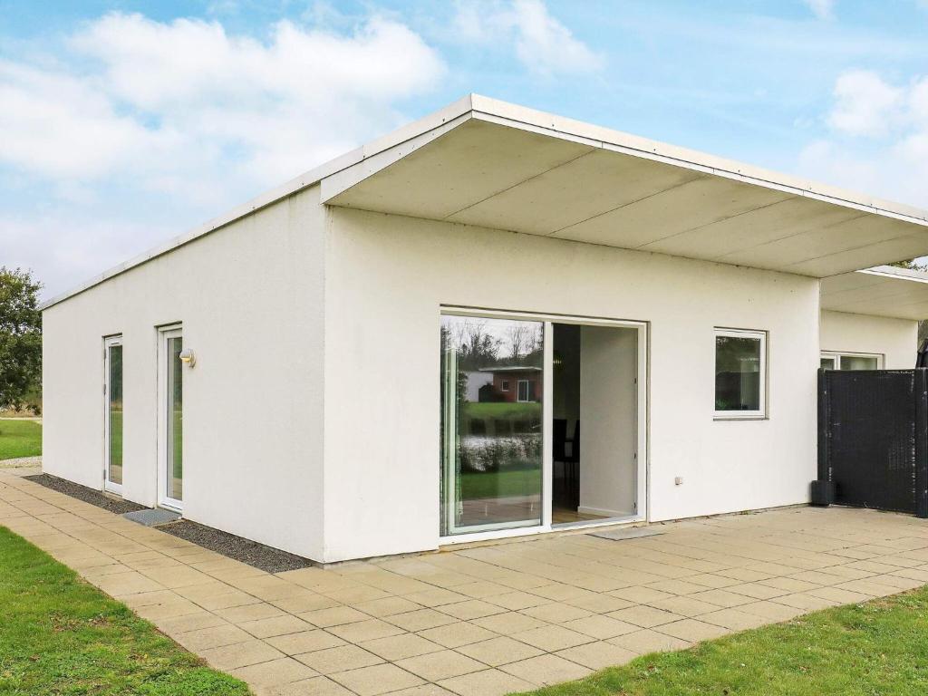 un edificio blanco con una gran puerta de cristal en 6 person holiday home in Ringk bing en Ringkøbing