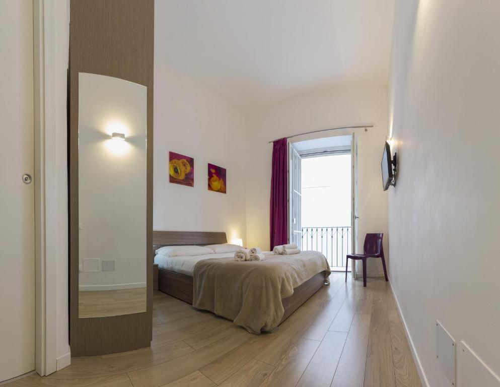 a bedroom with a bed and a large mirror at B&B Teatro in Palermo
