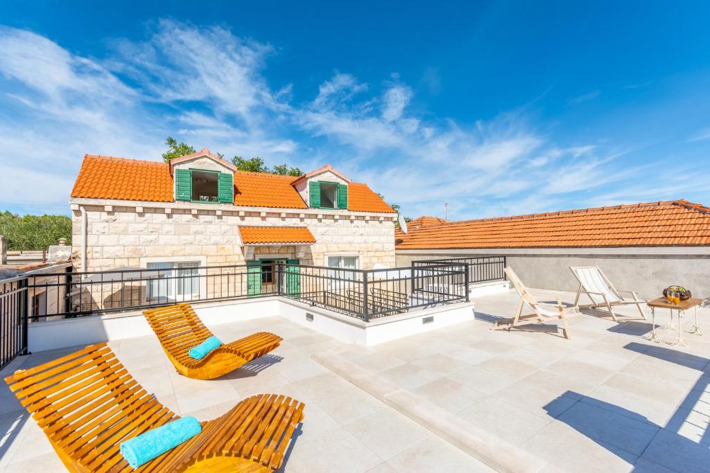 a patio with two chairs and a table on a roof at Villa Bunischa in Selca