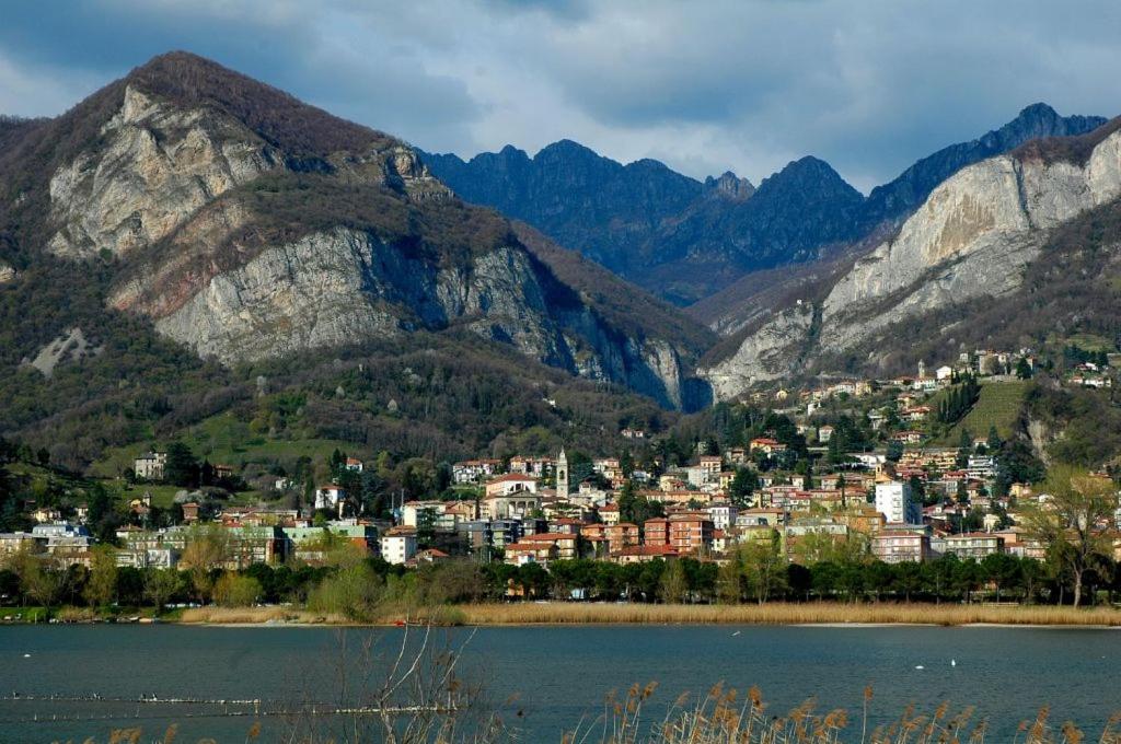 una città tra le montagne vicino a un corpo d'acqua di Hotel Locanda Mel a Calolziocorte