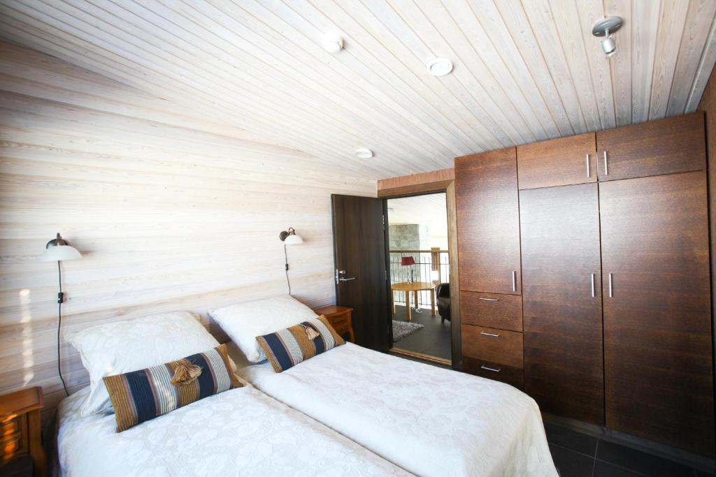 1 dormitorio con cama y techo de madera en Villa Little Peak, en Ruka