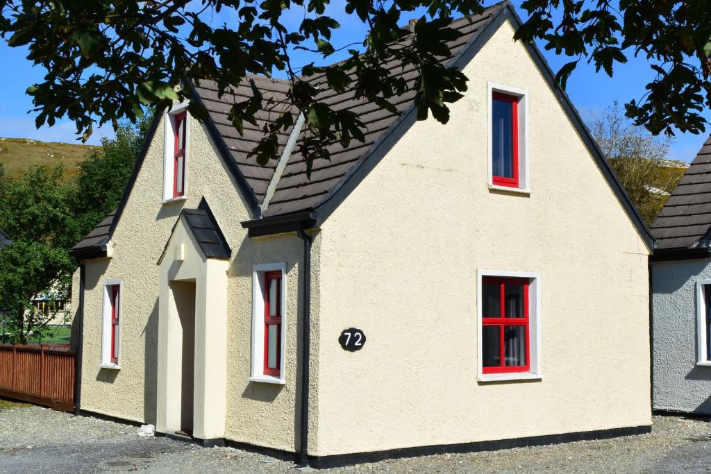 ein Haus mit roten Fenstern und einem Dach in der Unterkunft Cottage 346 - Clifden in Clifden