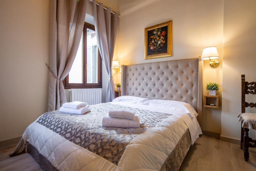 een slaapkamer met een bed met handdoeken erop bij Duomo Apartments in Florence