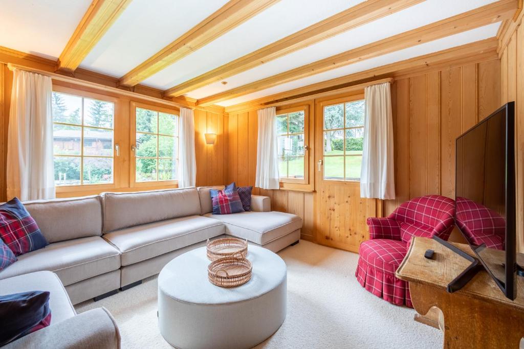 a living room with a couch and a tv at Chalet Cauma in Flims