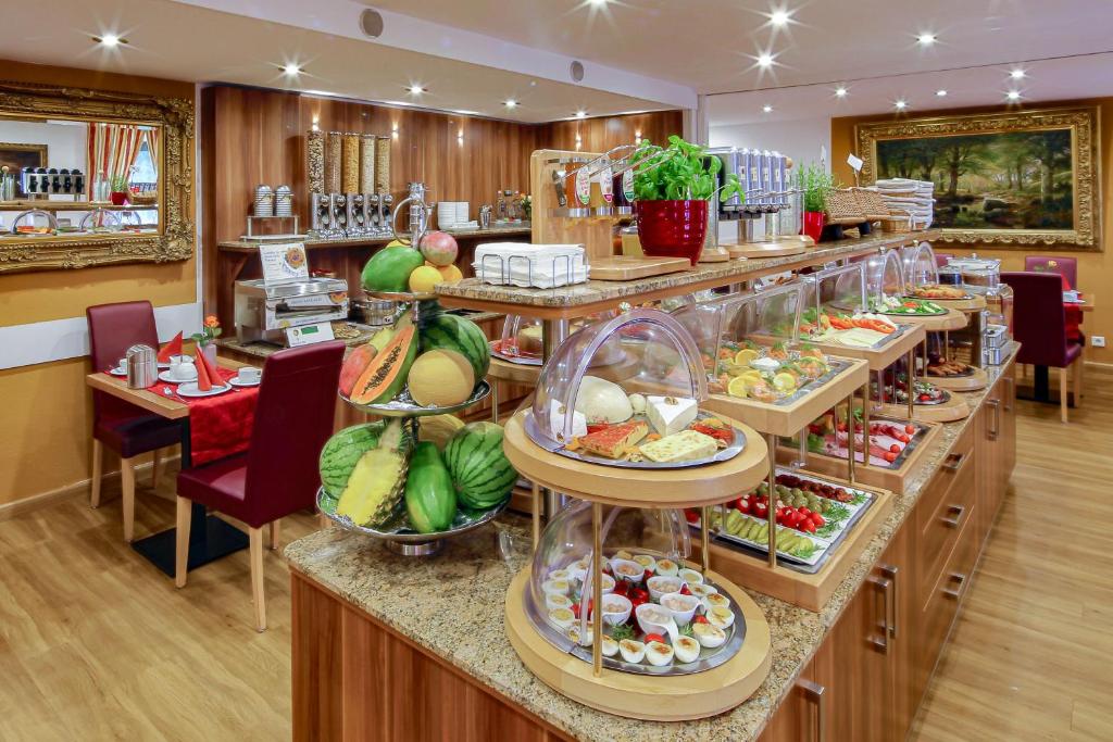 a buffet line with plates of food in a restaurant at TIPTOP Hotel Burgschmiet Garni in Nürnberg