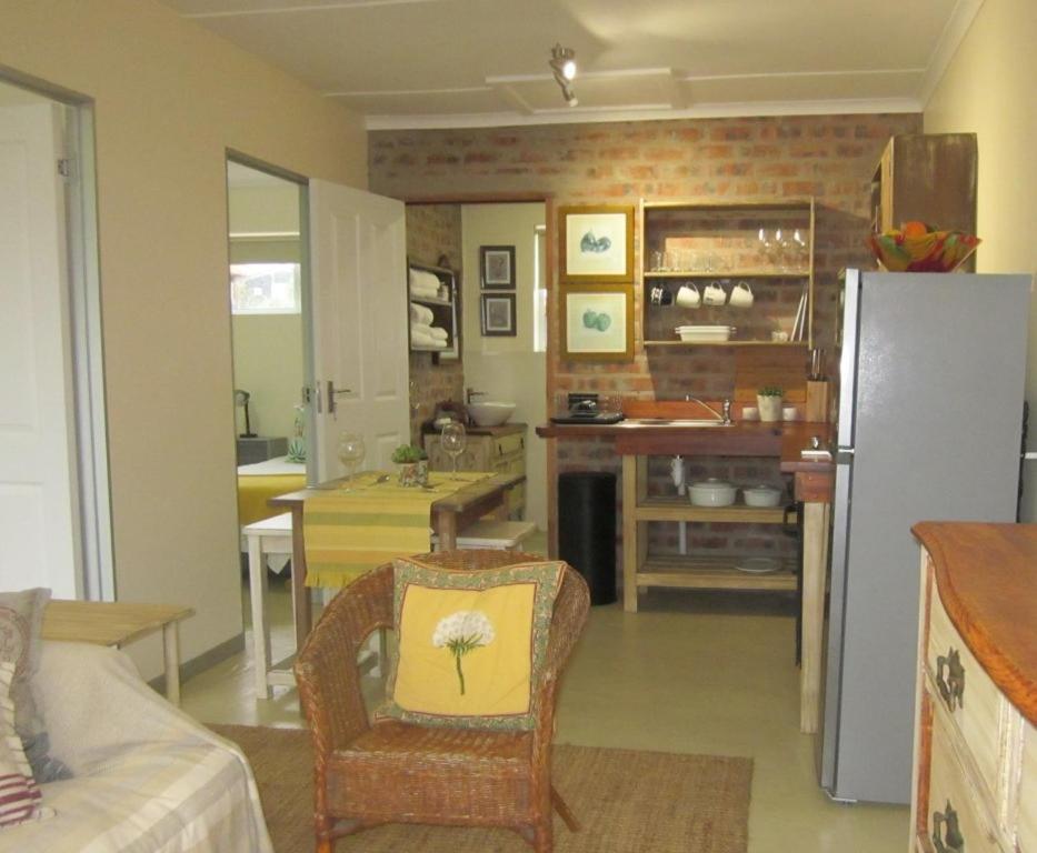 sala de estar con cocina con nevera en Little Sandpiper, en Cape St. Francis