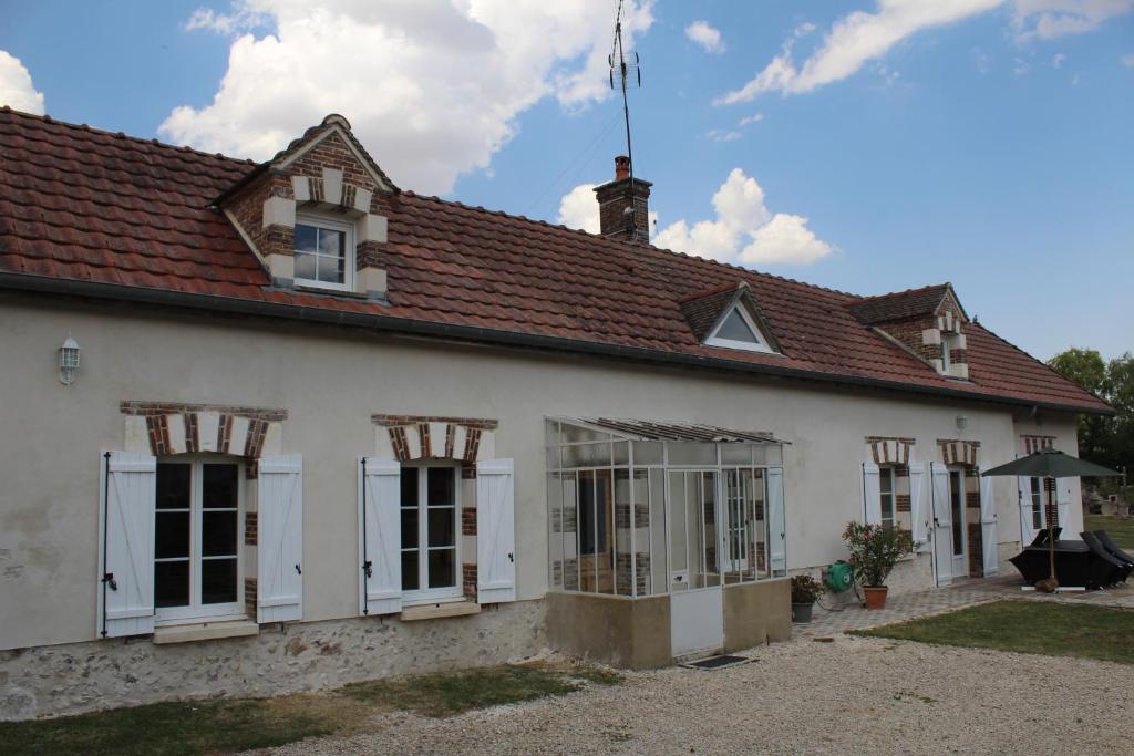 ein weißes Haus mit rotem Dach in der Unterkunft Maison Champêtre Huez in Faux-Villecerf