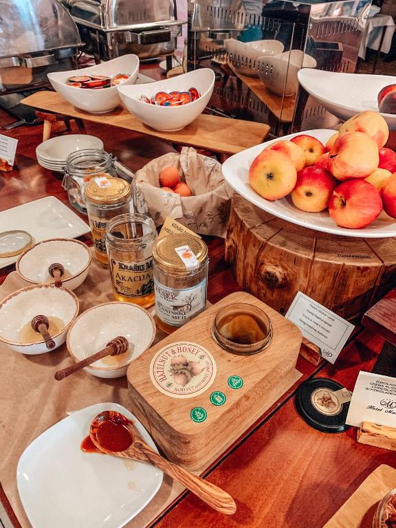 a table with plates of apples and bowls of food at Hotel Marina in Izola