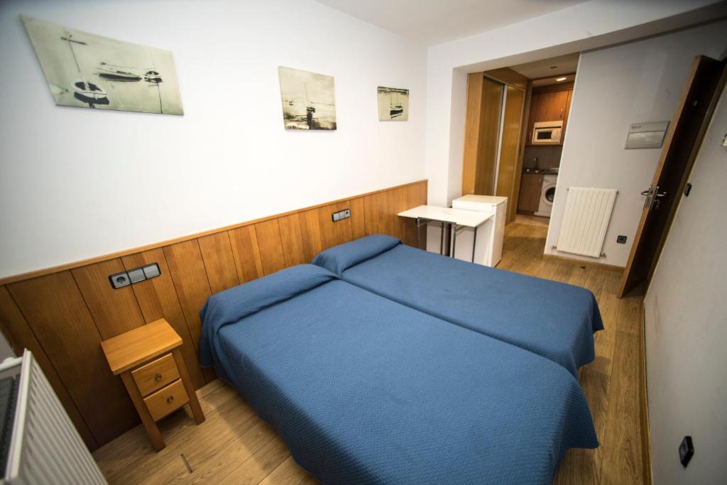 a small bedroom with a blue bed in a room at Hostal Caballeros in Soria