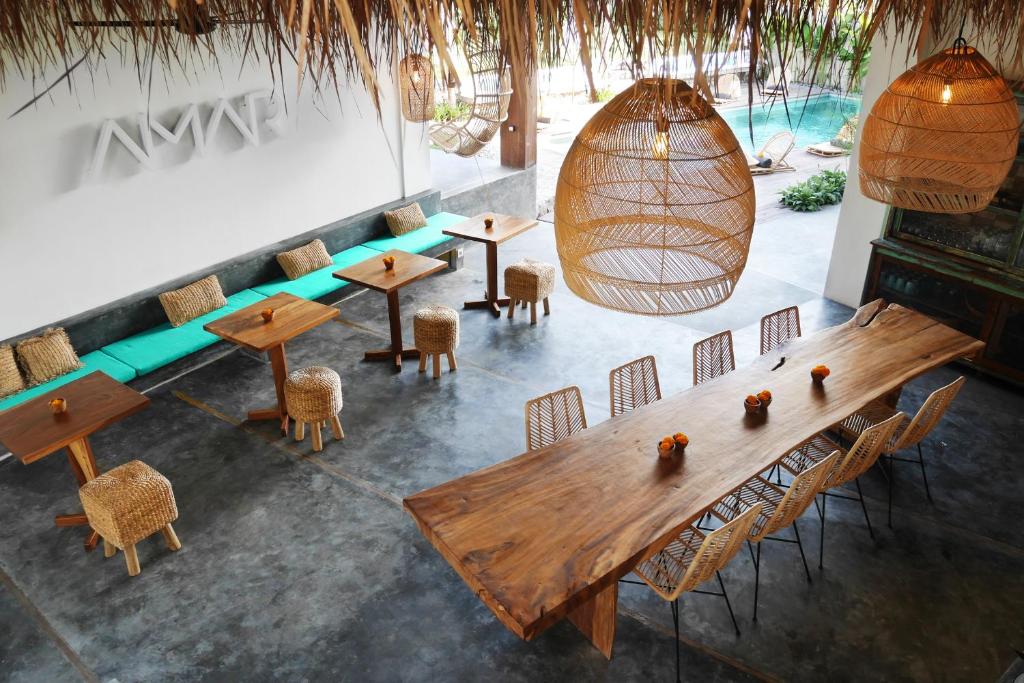 uma vista sobre um restaurante com mesas e cadeiras de madeira em Amar Boutique Hotel em Canggu