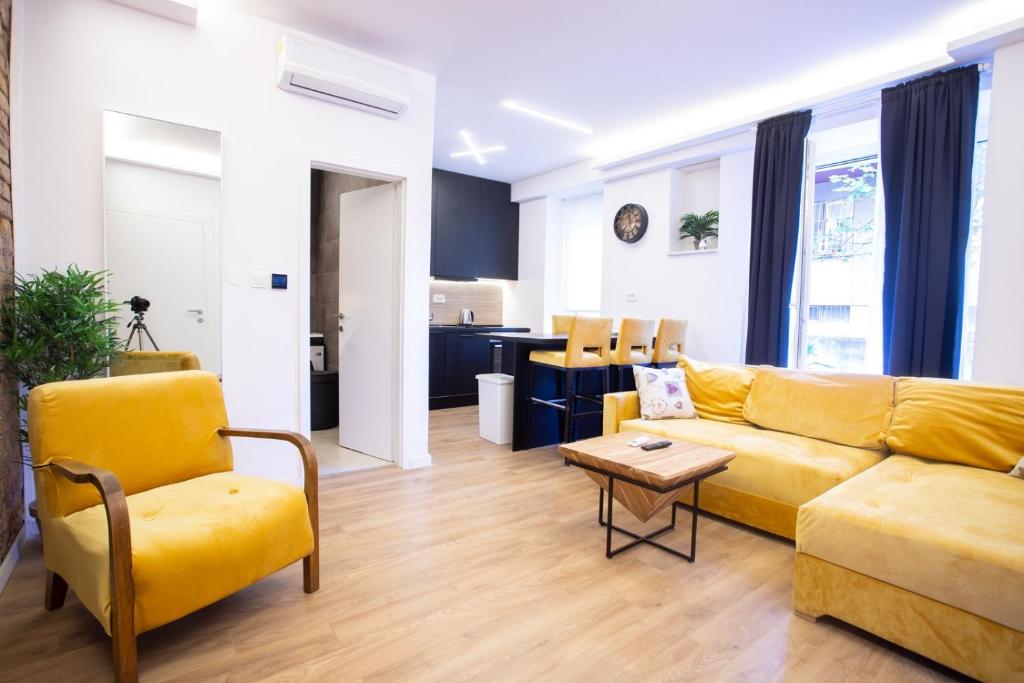 a living room with a yellow couch and a table at Pago Boutique Suites II in Zagreb