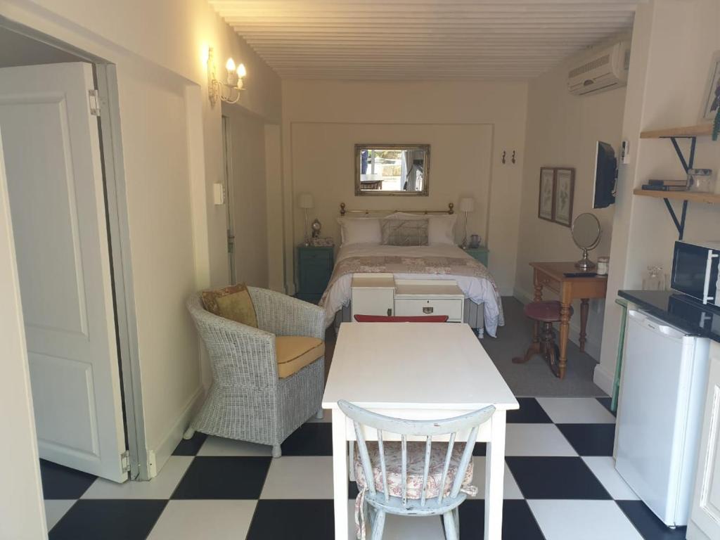 a bedroom with a bed and a table and chairs at Military House in Pietermaritzburg