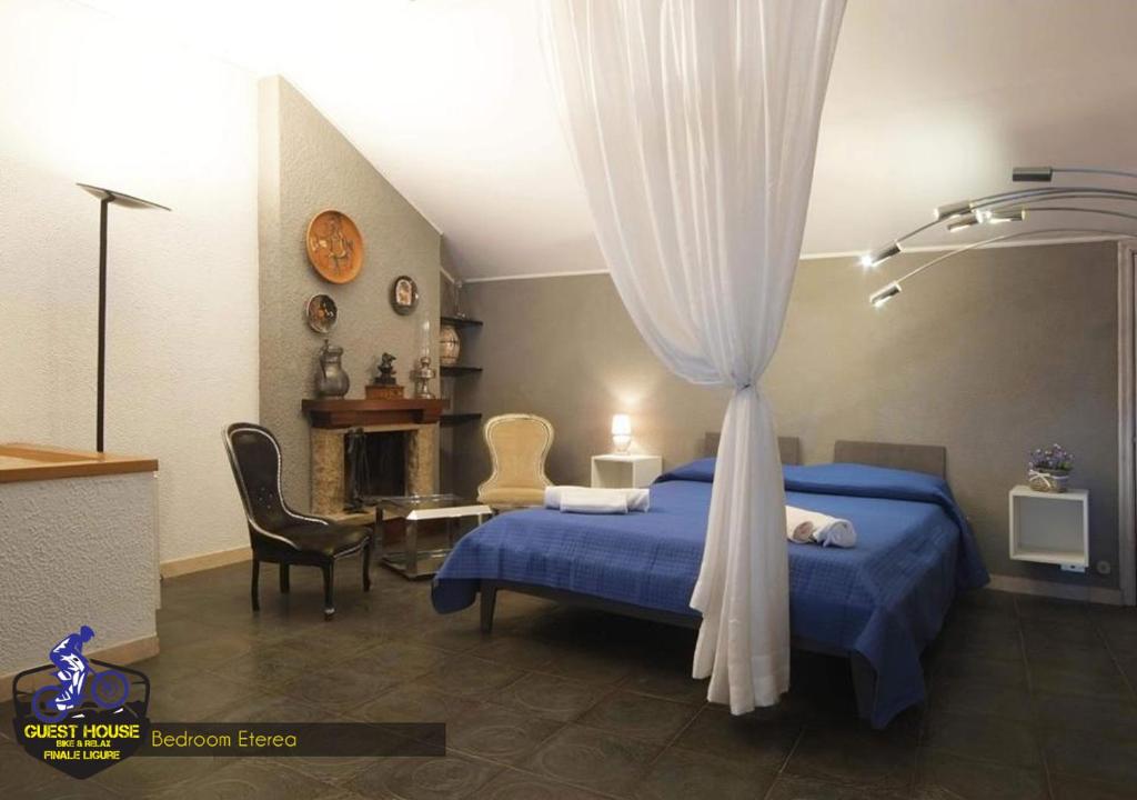 una camera con letto blu con tenda di Guest House Bike & Relax Finale Ligure a Finale Ligure