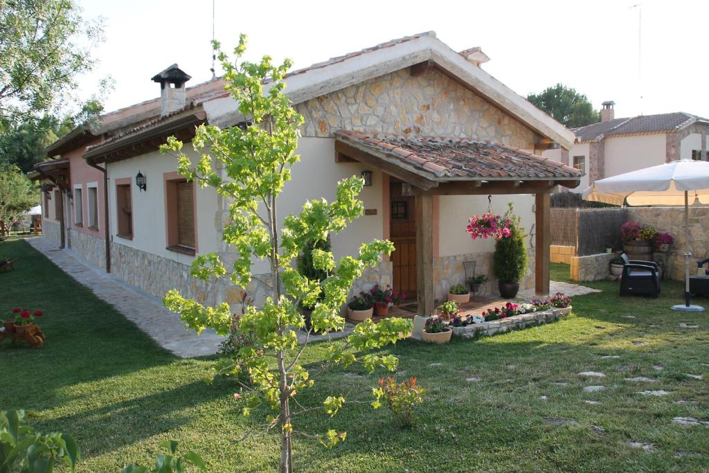 ein kleines Haus in einem Hof mit einem Baum in der Unterkunft Las casitas de La Velilla in Pedraza