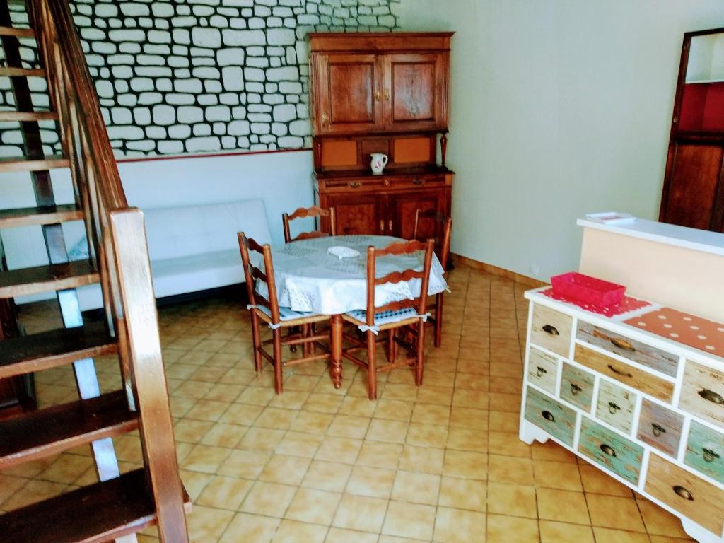 een keuken met een tafel en stoelen in een kamer bij Châtellenie d Ardennes in Fontenay-le-Comte