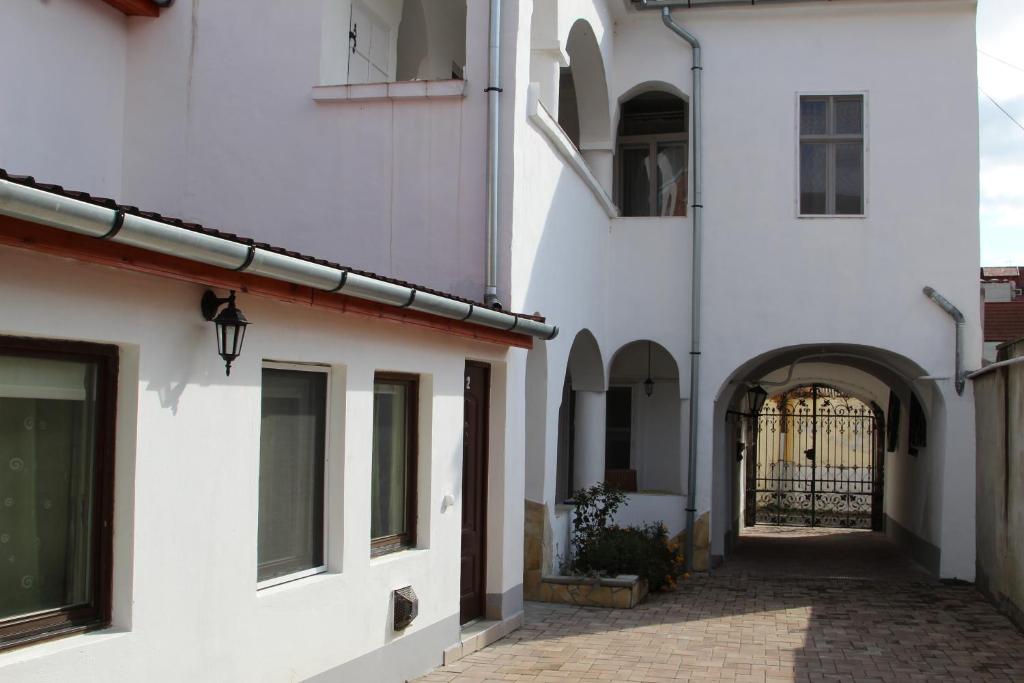 an alley between two white buildings with a gate at Demetrovics Udvarház in Eger