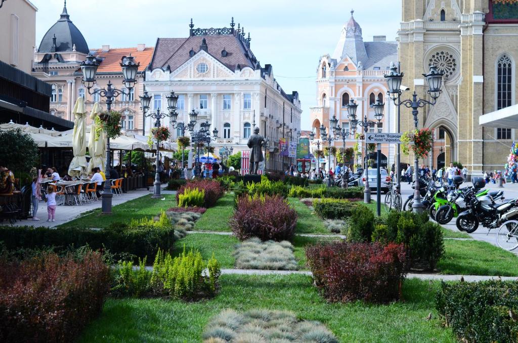 uma rua da cidade com um parque em frente a um edifício em Downtown apartment in walk zone with 3 bedrooms and garage em Novi Sad