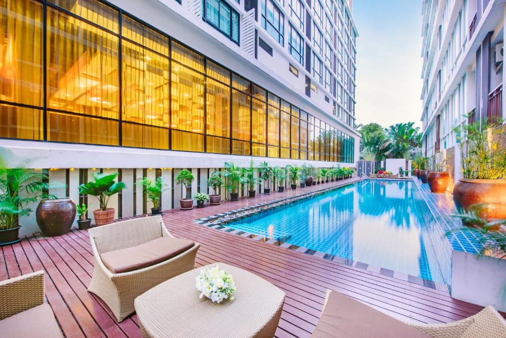 a swimming pool in the middle of a building at Mida Hotel Ngamwongwan - SHA Plus in Nonthaburi