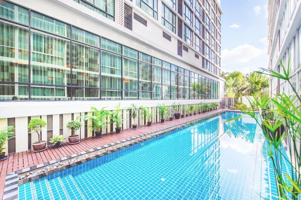 a swimming pool in front of a building at Mida Hotel Ngamwongwan - SHA Plus in Nonthaburi