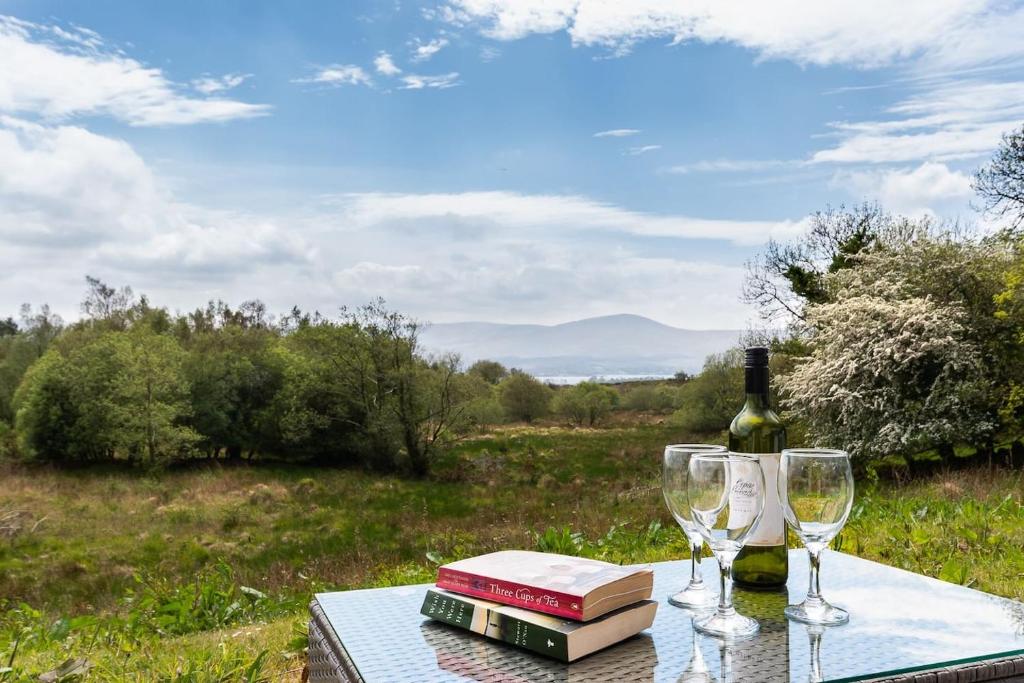 a table with a bottle of wine and two glasses at Bay View House in Kenmare