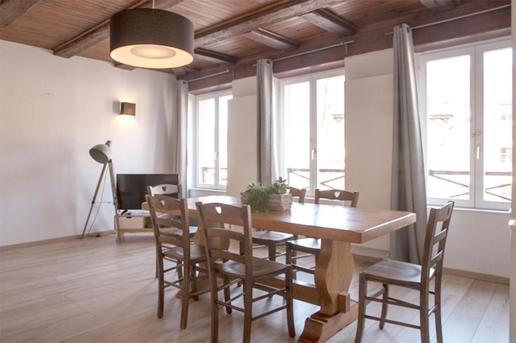 a dining room with a wooden table and chairs at Petite Venise Grand Duplex Turenne Hyper Centre in Colmar