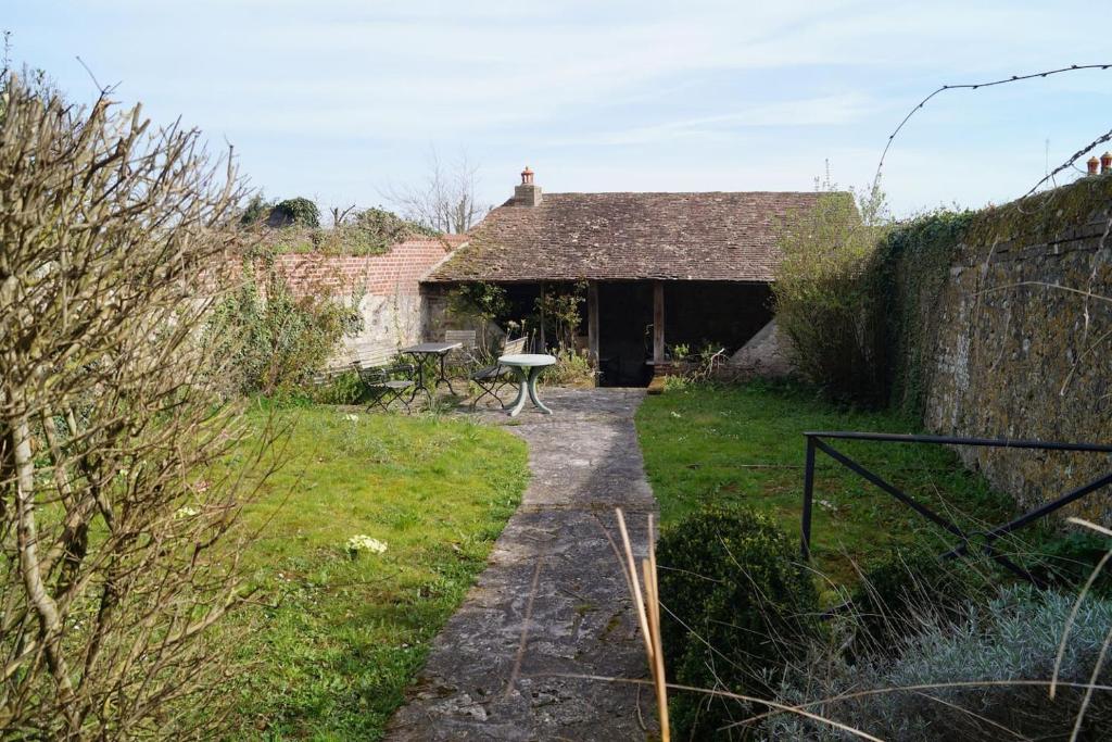 an old cottage with a table in the yard at Le Rock Studio in Honfleur