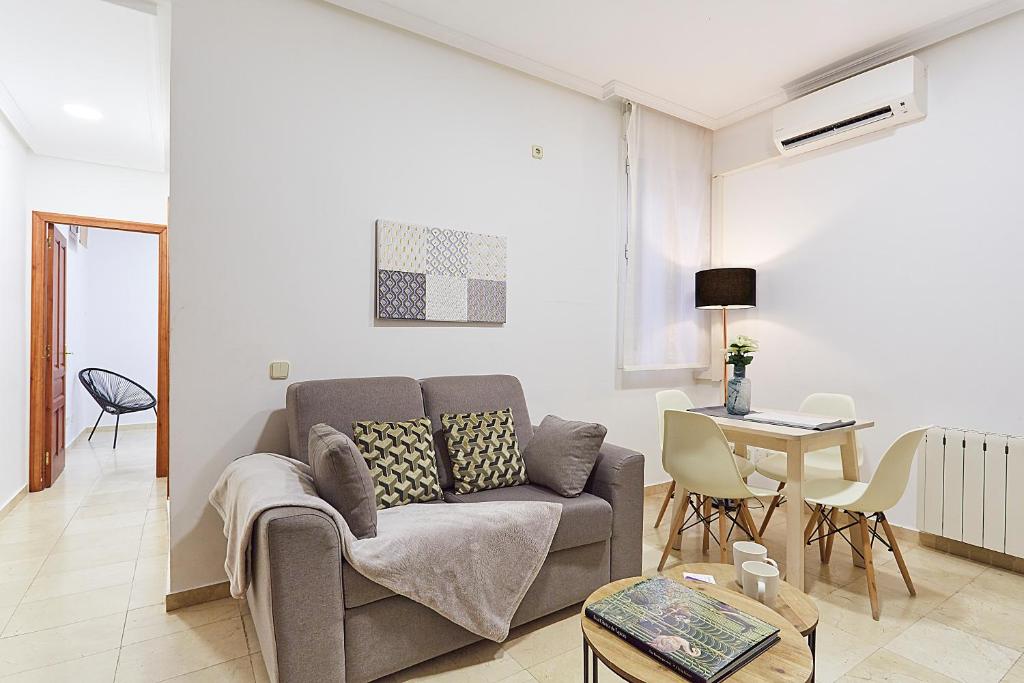 ein Wohnzimmer mit einem Sofa und einem Tisch in der Unterkunft LEEWAYS APARTMENT XIX in GRAN VÍA in Madrid