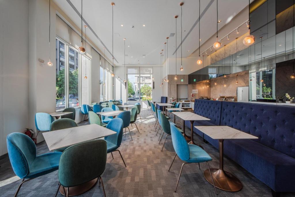 a restaurant with blue chairs and tables at Ramble Hotel in Taichung