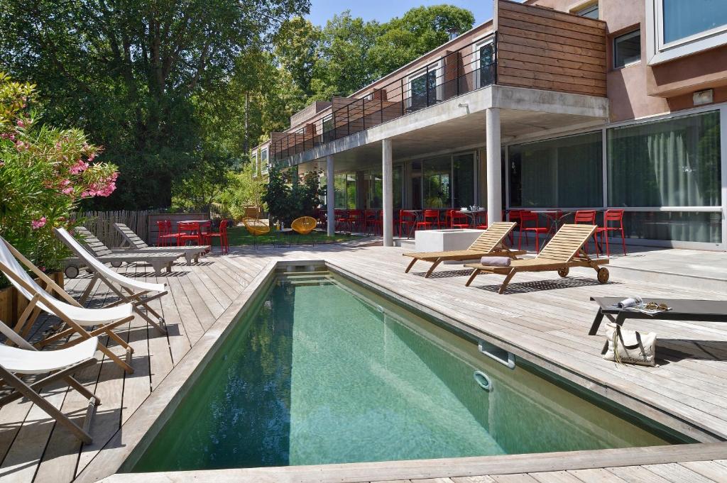 a swimming pool with chairs and a house at Boutique Hotel Artemisia in Bastelica