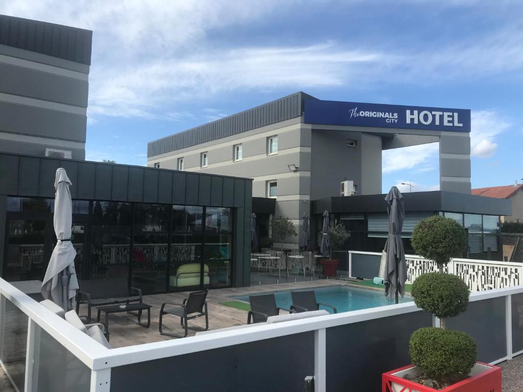 um hotel com piscina em frente a um edifício em The Originals City, Hôtel Hélios, Roanne Nord (Inter-Hotel) em Mably