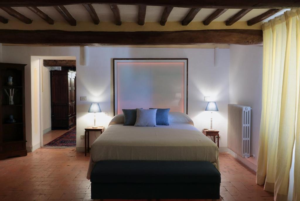 a bedroom with a bed and two lamps on tables at Suite Testamatta in Pisa