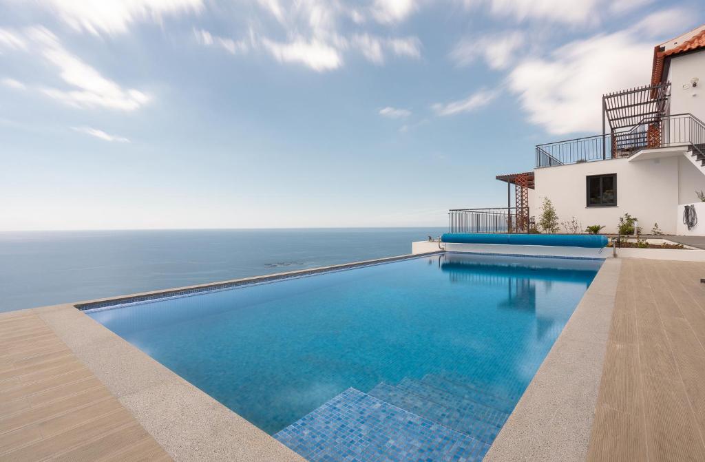 a swimming pool with a view of the ocean at Seasky Arco in Arco da Calheta