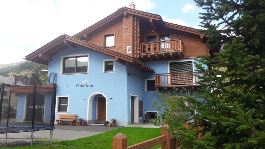 een blauw huis met een houten dak bij Chalet Teresa in Livigno