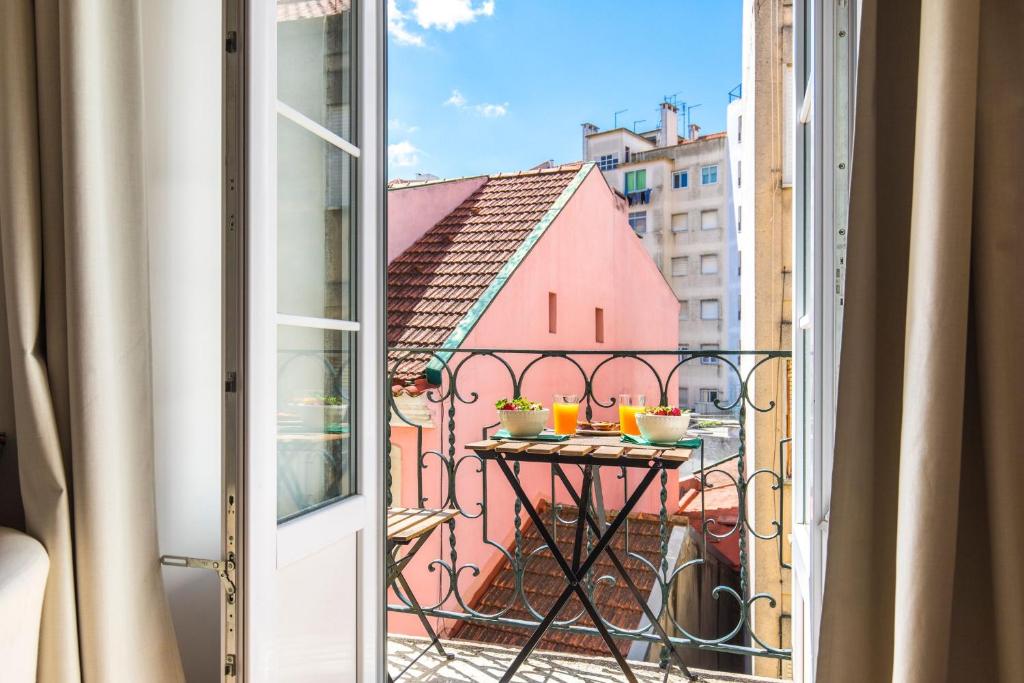 リスボンにあるLovelyStay - Sunny flat w/ balcony overseeing Graca and Riverの建物の景色を望むバルコニー(テーブル付)