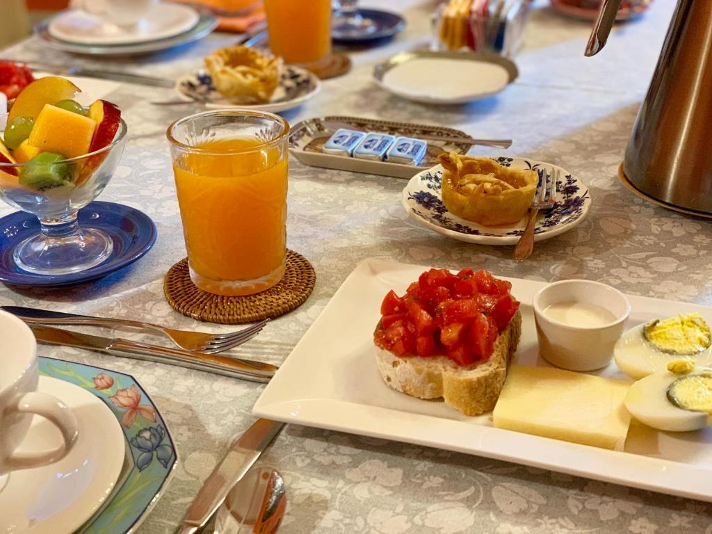 a table with a plate of food and a glass of orange juice at Villino Eleonora in Parghelia
