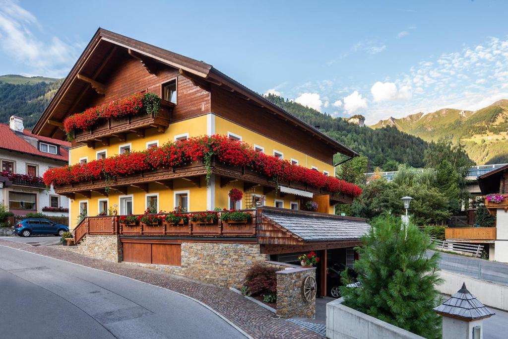 a building with red flowers on the side of it at Haus Rainer in Matrei in Osttirol