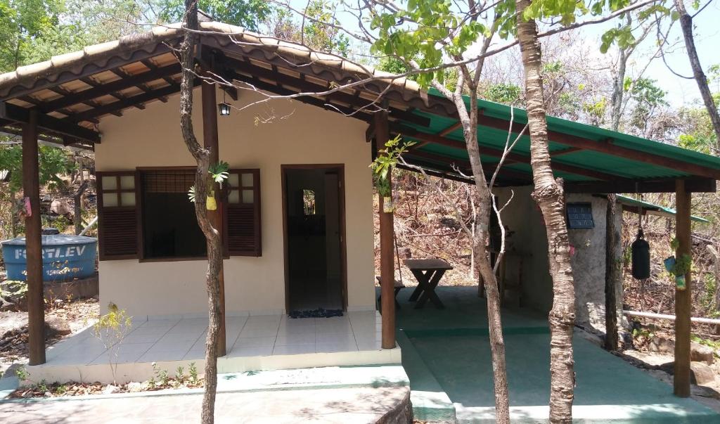 une petite maison avec un toit vert dans l'établissement Chalés Santo Verde, à Goiás