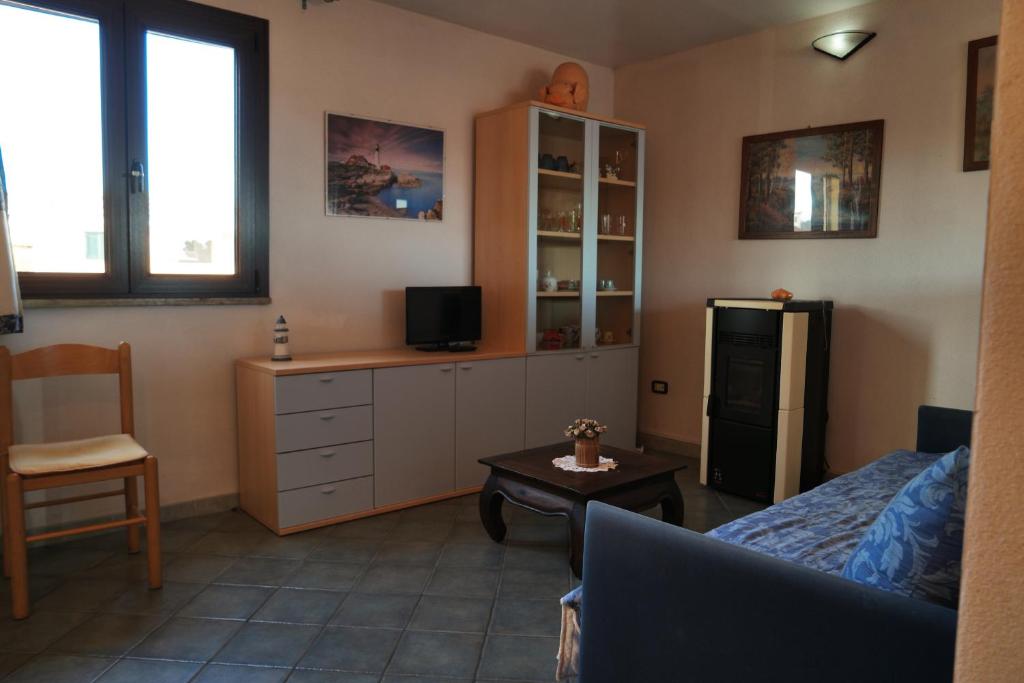 Appartamento Sardegna في بورتو سان باولو: غرفة معيشة مع أريكة وثلاجة
