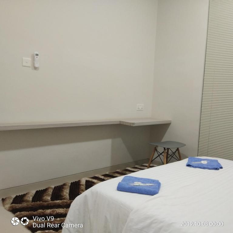 a bedroom with two beds with blue towels on them at SleepRest @ The Home Shoutlink in Nagoya