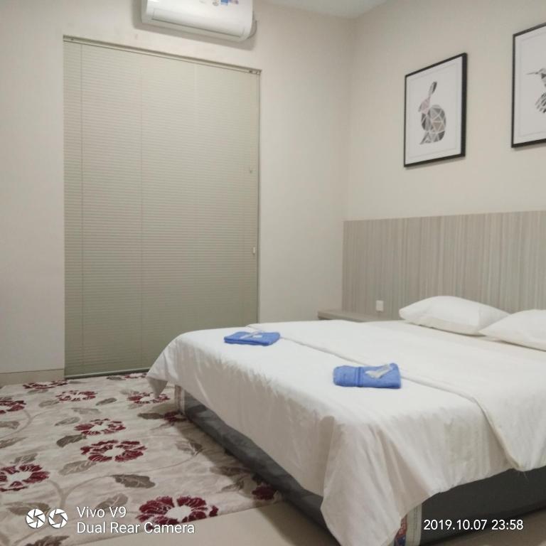 a bedroom with a large bed with blue towels on it at SleepRest @ The Home Shoutlink in Nagoya