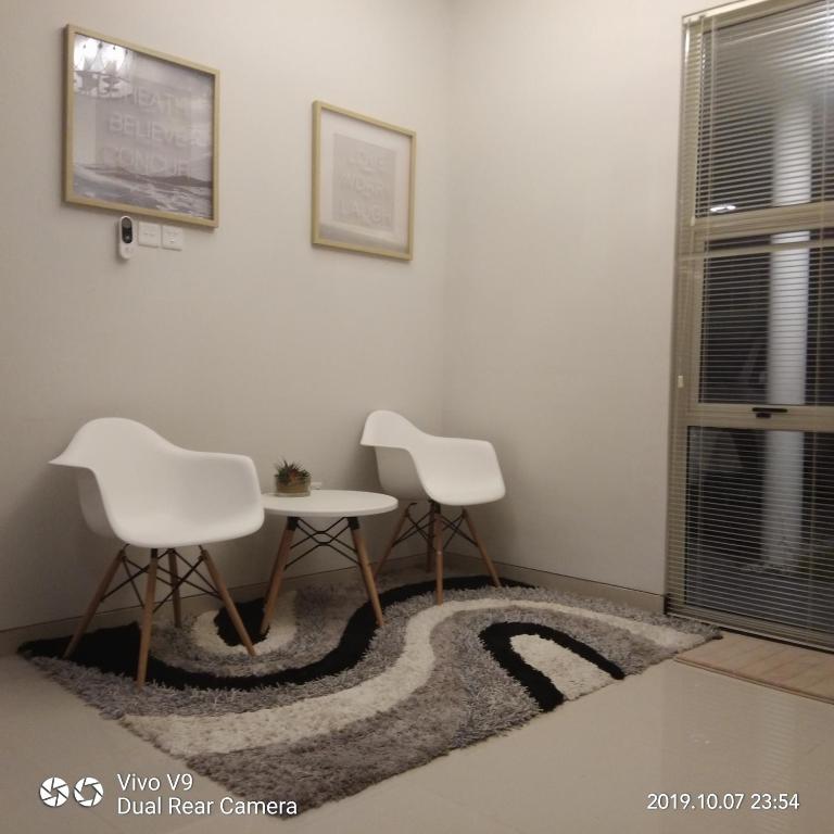 two white chairs and a table in a room at SleepRest @ The Home Shoutlink in Nagoya