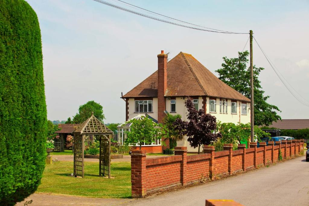 a house with a brick fence in front of it at Elmcroft Guest House in Epping