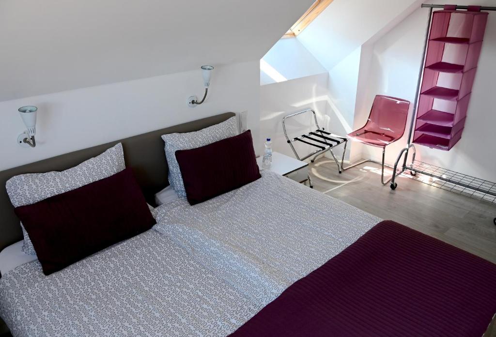 een slaapkamer met een bed en een roze stoel bij In De Achtste Hemel in Schimmert