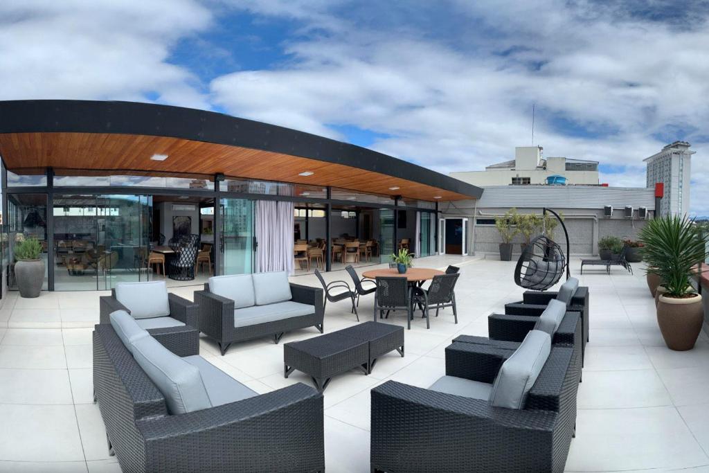 a patio with couches and tables and chairs at Rede Andrade Criciuma in Criciúma