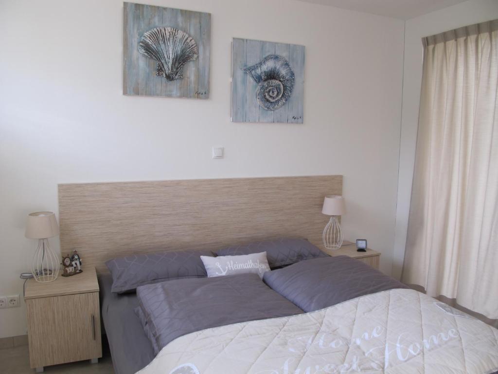 a bedroom with a bed and two pictures on the wall at Seestern - Ferienhaus am Quendorfer See (Nr. 5) in Schüttorf